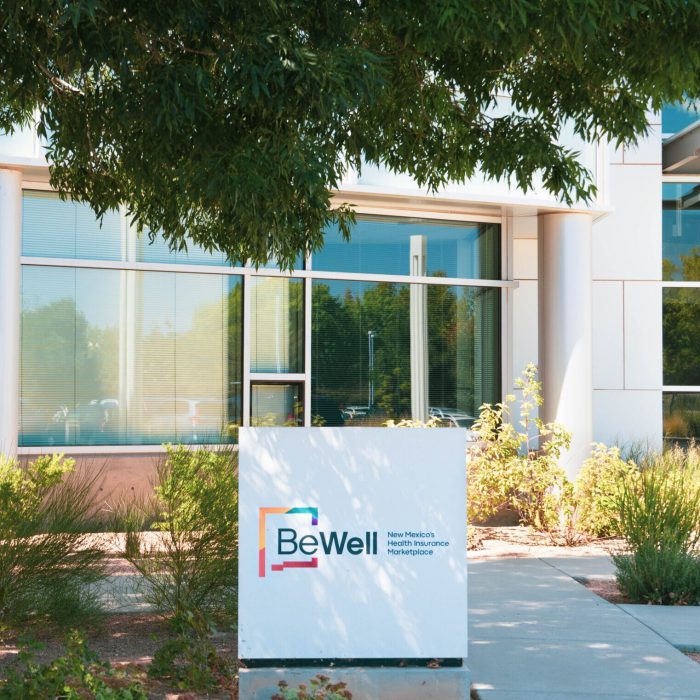 In front of the BeWell office of the sign with the BeWell logo